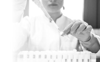 Close up of biologics manufacturing scientist pipetting into an eppendorf