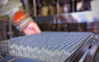 Vials in tray being loaded into lyophiliser during peptide manufacturing